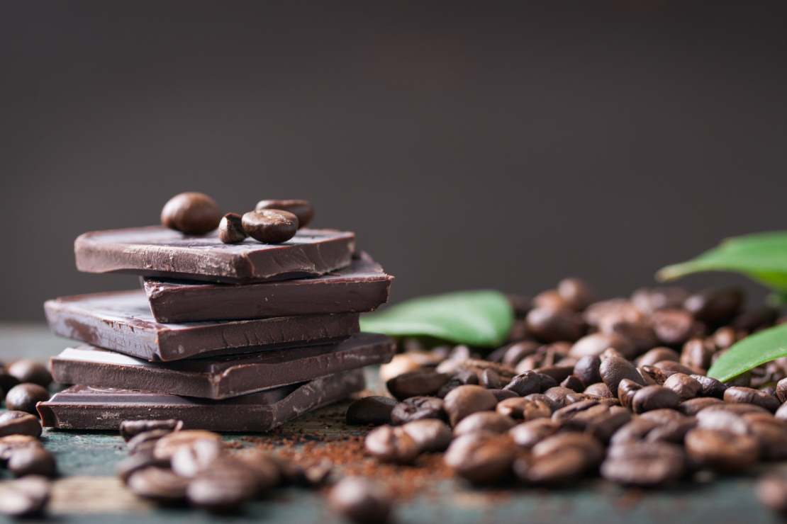 Pieces of dark chocolate with cocoa beans, symbolizing healthy indulgence.