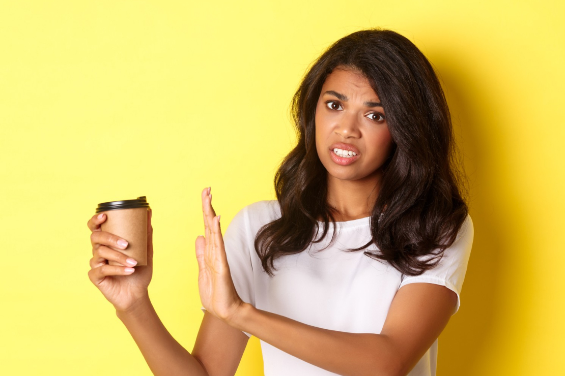 A calendar with a 7-day week highlighted, with coffee cups on the first few days, then tea, then water, symbolizing a caffeine reset plan.